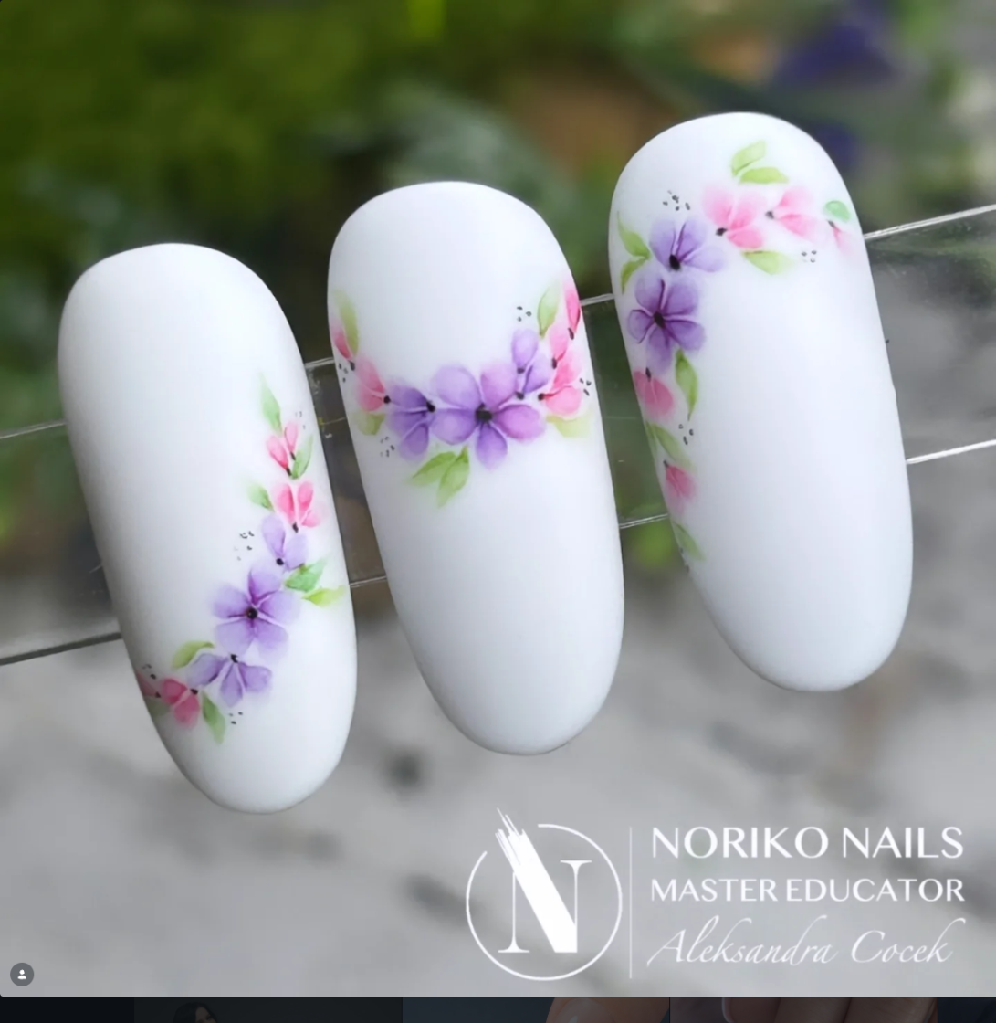Białe matowe paznokcie z delikatnymi fioletowymi i różowymi kwiatkami